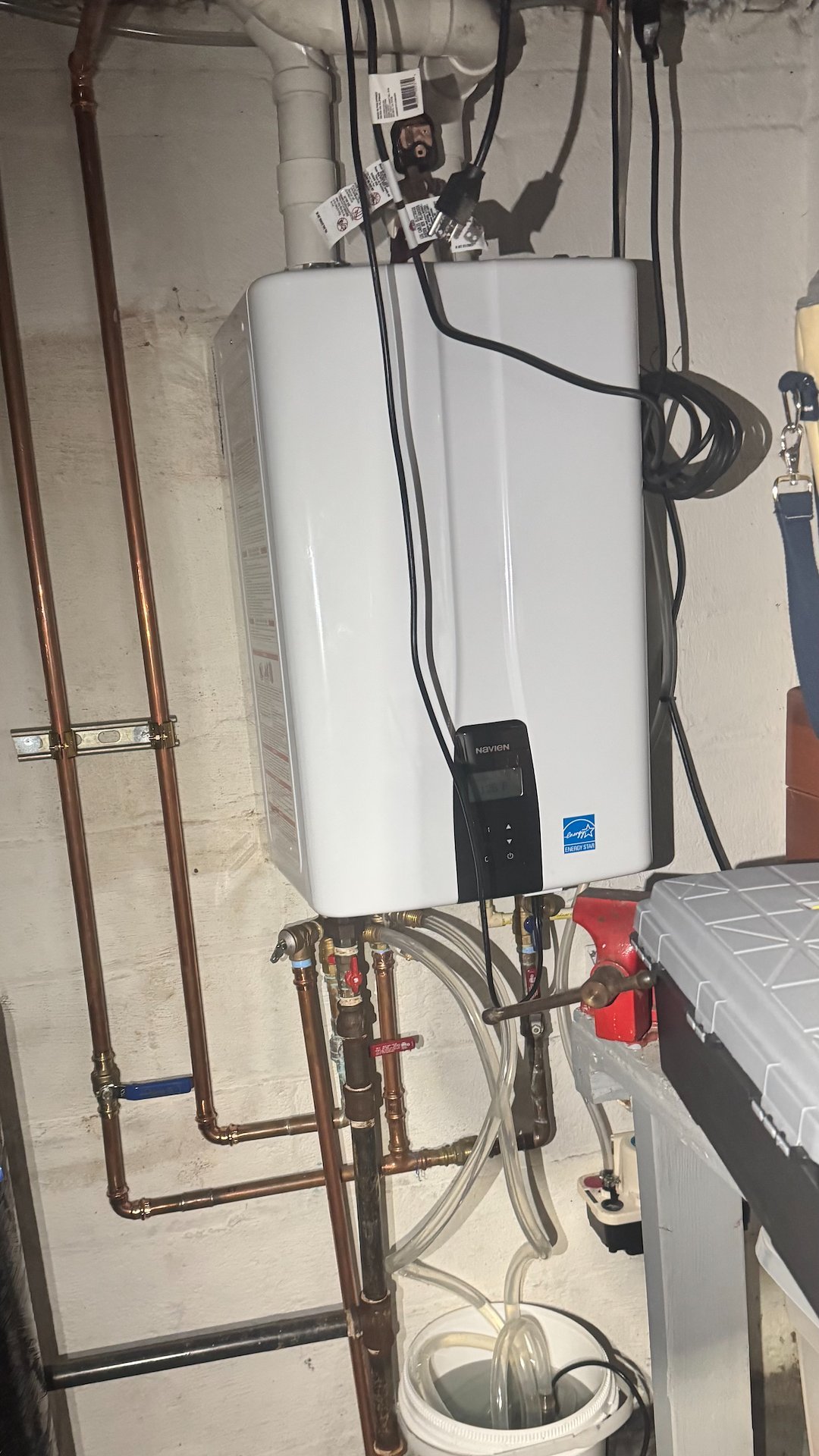 Wall-mounted tankless water heater with new copper piping installed in Alexandria, VA
